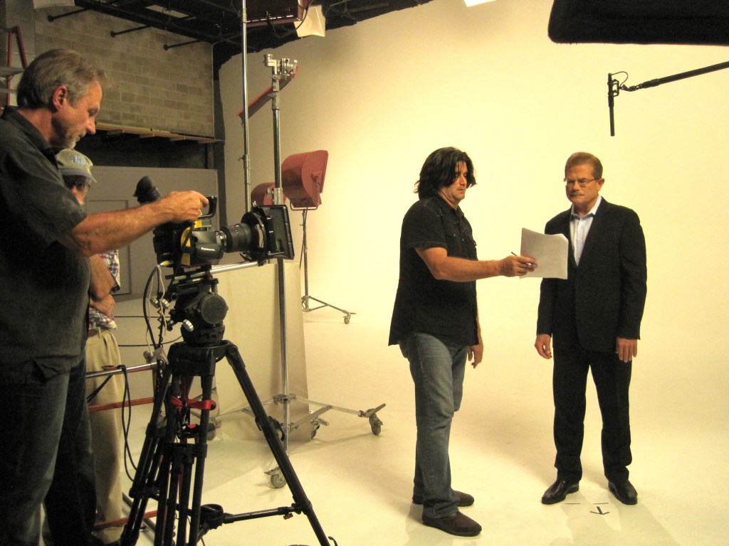 Producer reviewing script with talent on-camera, as the camera operator gets the shot ready